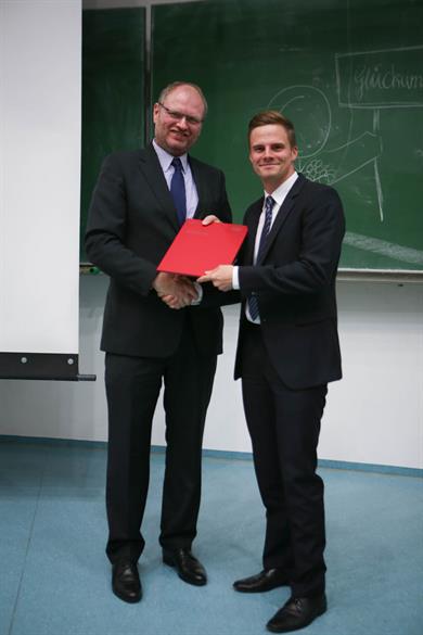 Man sieht, wie Prof. Dr. Peter C. Fischer, jeder Absolventin und jedem Absolventen persönlich gratuliert, hier Herrn Stefan Rüdiger.